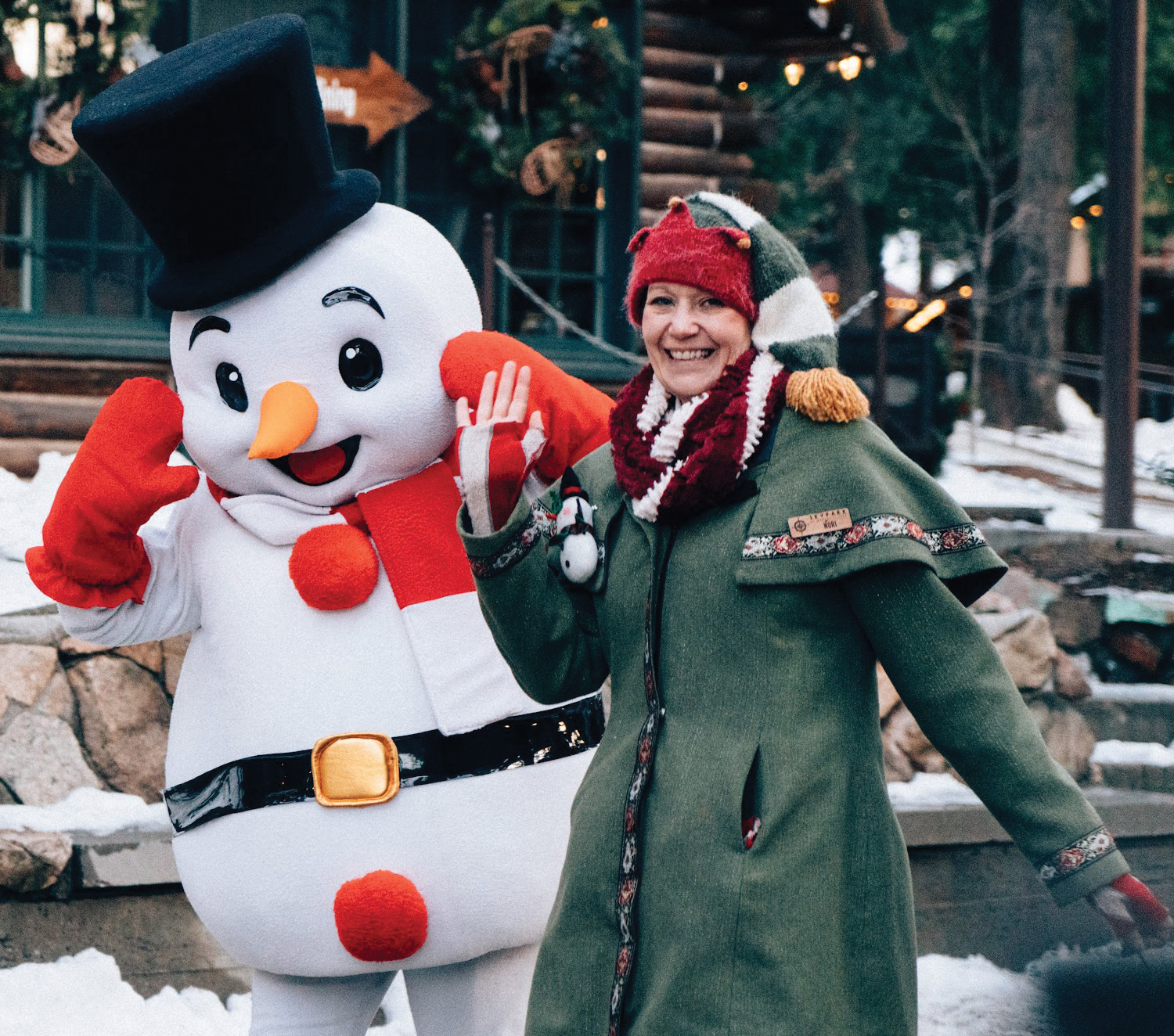 Frosty the Snowman and a SkyPark employee wave to the camera.
